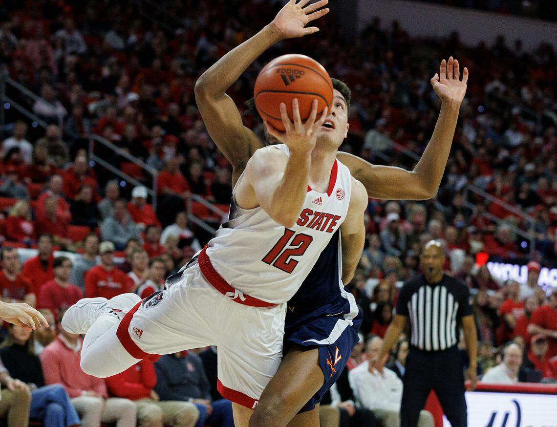 N.C. State’s Michael O’Connell drives by Virginia’s Leon Bond III during the second half of the Wolfpack’s 76-60 win on Saturday, Jan. 6, 2024, at PNC Arena in Raleigh, N.C.