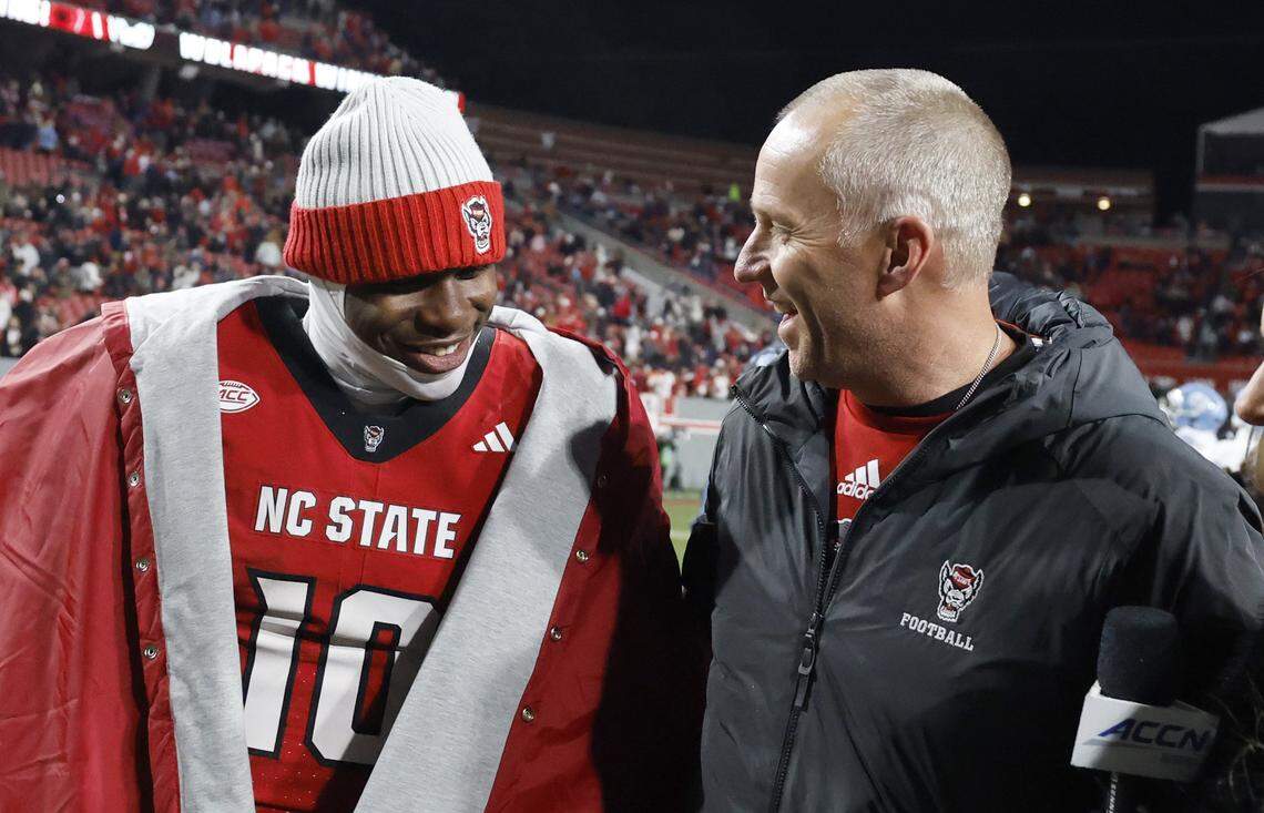 N.C. State head coach Dave Doeren laughs with quarterback Will Wilson (10) after N.C. State’s 42-19 victory over UNC at Carter-Finley Stadium in Raleigh, N.C., Saturday, Nov. 29, 2025.