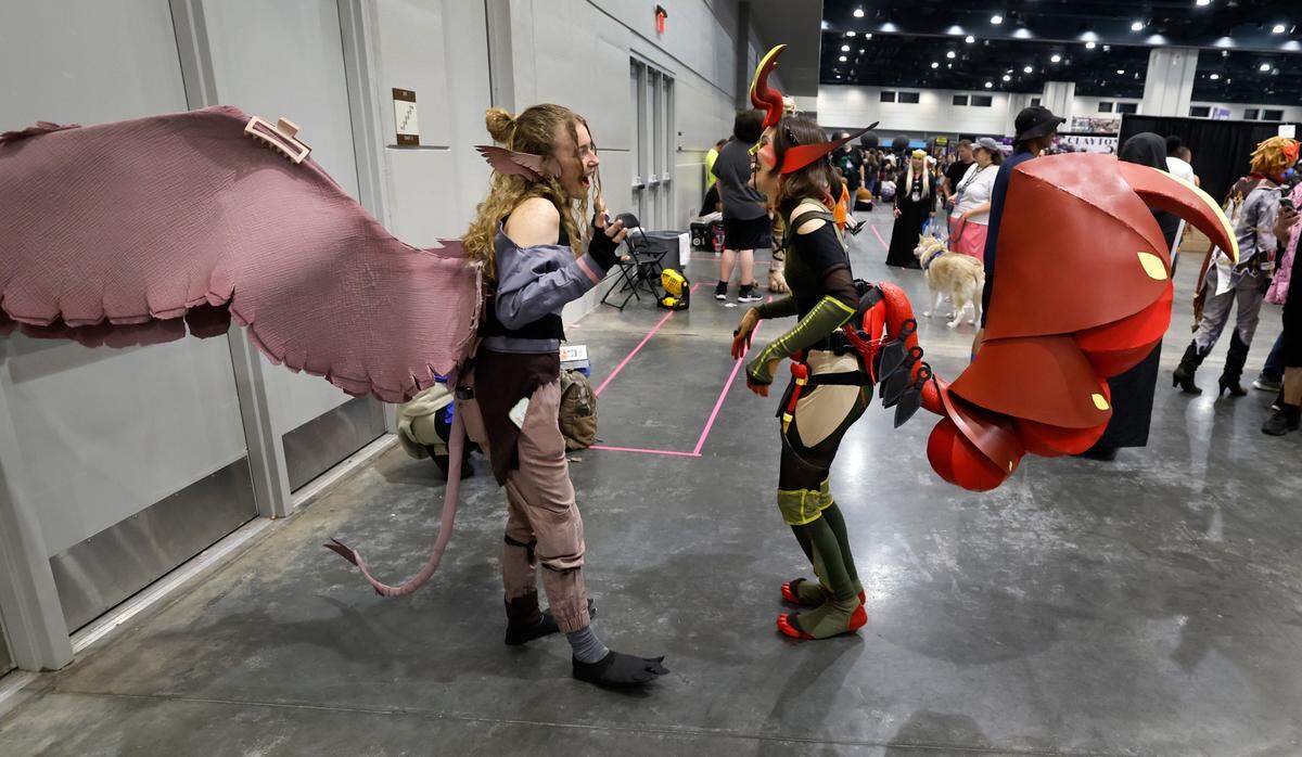 Amelia Grogan of Raleigh, left, laughs with Tatem Damron of Winnipeg during GalaxyCon Raleigh at the Raleigh Convention Center Sunday, July 28, 2024. The two are dressed in their own original costumes.