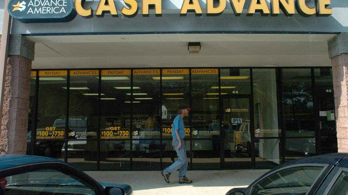 In this file photo, a man walks past the office of a payday lender in Durham. Some experts say a 2023 proposal to cap credit card late fees could end up hurting small banks and low-income earners, forcing some consumers to return to using services that extract greater fees.