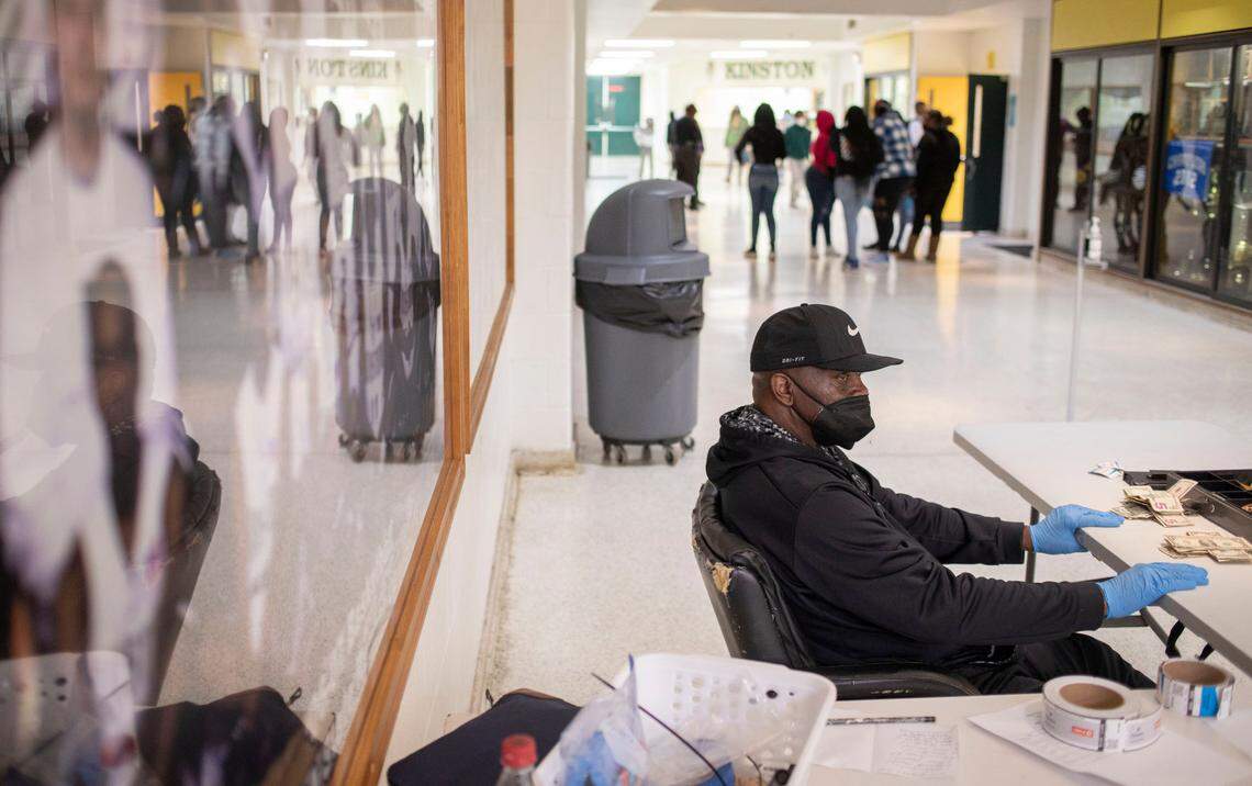 Van Simmons waits for game attendees to bring him their tickets as they enter the gym at Kinston High School in Kinston, N.C. for a basketball game on Jan. 27, 2022.