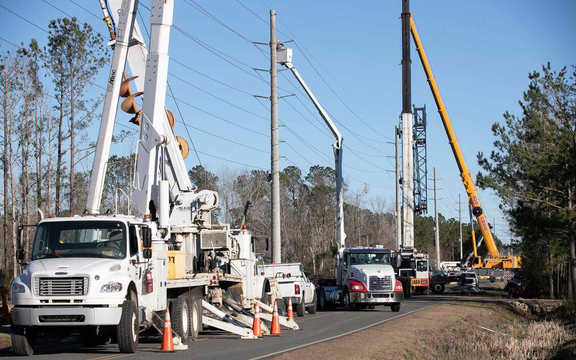 Utility crews work to restore a main power line along Green Bay Road on Tuesday, February 16, 2021 in Brunswick County after a tornado moved through the area on Monday night causing widespread damage.