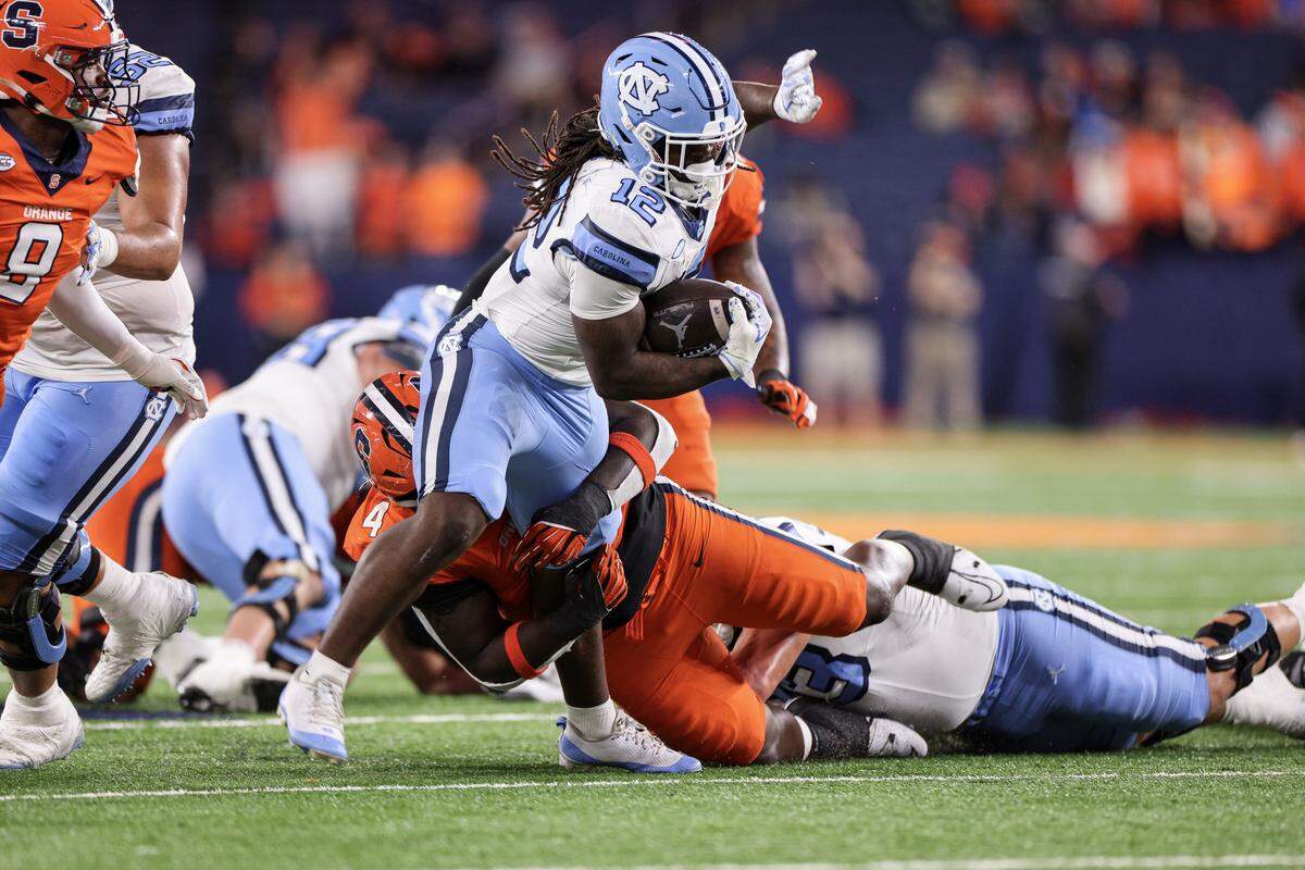 Demon June (12) of the North Carolina Tar Heels is tackled by Dion Wilson Jr. of the Syracuse Orange during the third quarter at JMA Wireless Dome on Oct. 31, 2025 in Syracuse, New York.