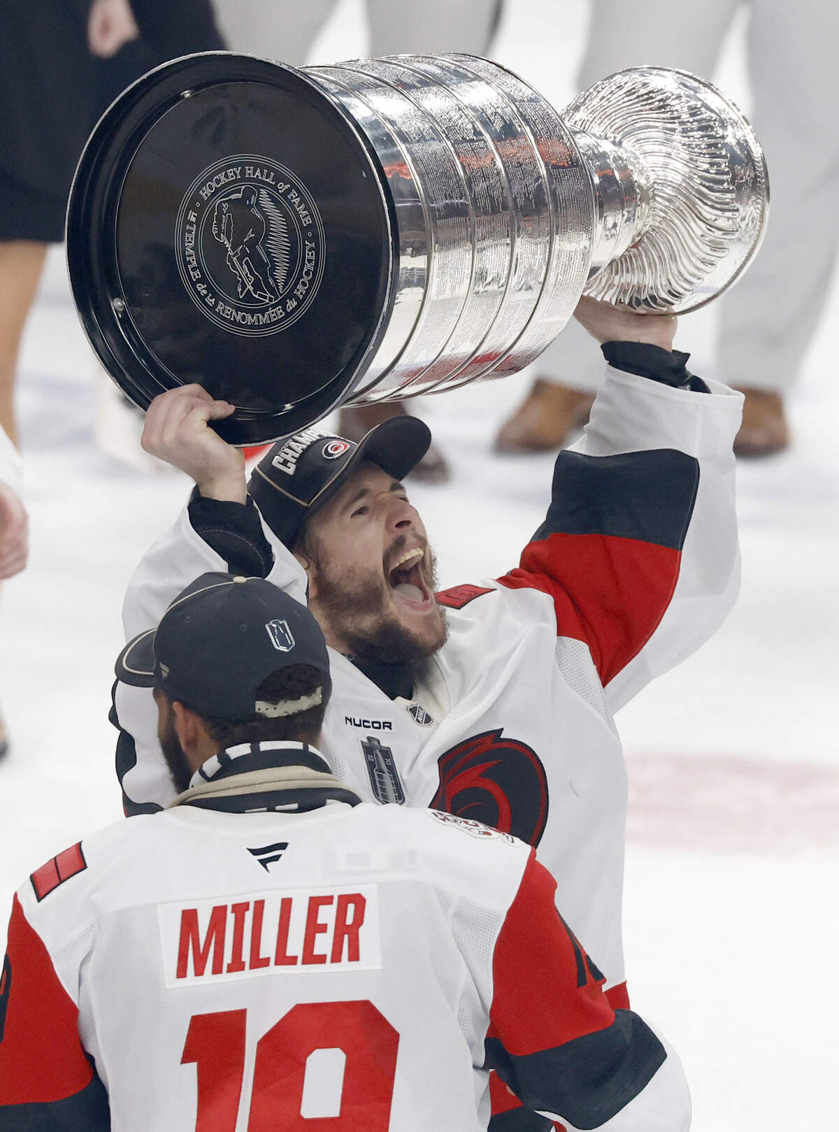 Carolina's Brandon Bussi (32) raises the Cup after getting it from K'andre Miller (19) after Hurricanes’ 3-0 victory over the Vegas Golden Knights to win the Stanley Cup at T-Mobile Arena in Las Vegas, Nev., Sunday, June 14, 2026.