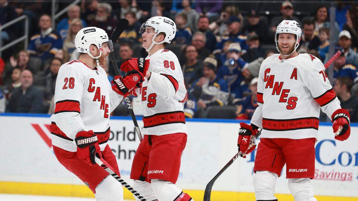 Carolina Hurricanes’ Martin Necas (88) celebrates with Carolina Hurricanes’ Ian Cole (28) and Carolina Hurricanes’ Jaccob Slavin (74) after scoring a goal during the first period of an NHL hockey game against the St. Louis Blues on Saturday, March 26, 2022 in St. Louis. (AP Photo/Michael Thomas)