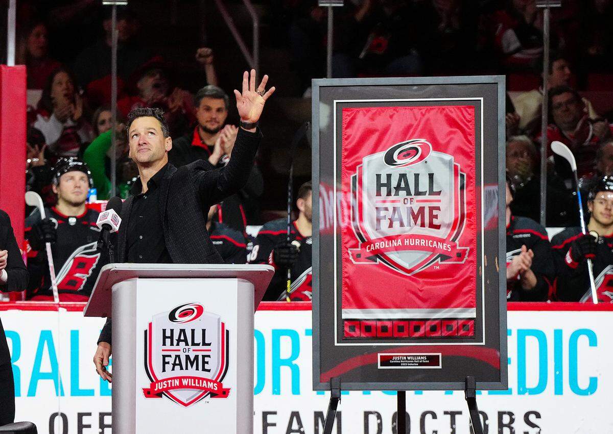 Jan 15, 2024; Raleigh, North Carolina, USA; Carolina Hurricanes left wing Justin Williams (14) waves to the fans on his team Hall of Fame Ceremony against the Los Angeles Kings at PNC Arena.