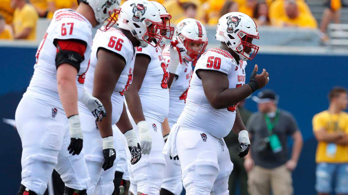 N.C. State center Grant Gibson (50) and the offensive line get ready during the first half of N.C. State’s game against West Virginia at Milan Puskar Stadium in Morgantown, W.V., Saturday, Sept. 14, 2019.