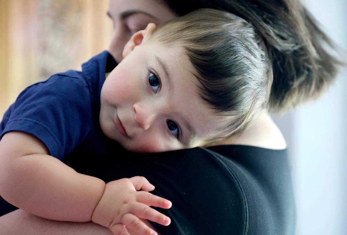 Stefanie Wisda’s son rests on his mother’s shoulder.