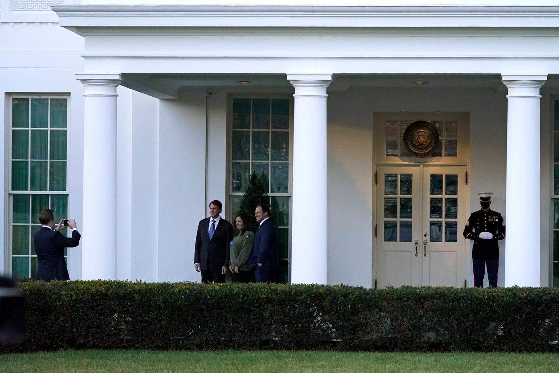 Visitors take photos as a Marine guard stands at the entrance to the West Wing of the White House, signifying that President Donald Trump is in the Oval Office, while impeachment proceedings continue at the U.S. Capitol against Trump in Washington, Wednesday, Jan. 13, 2021.