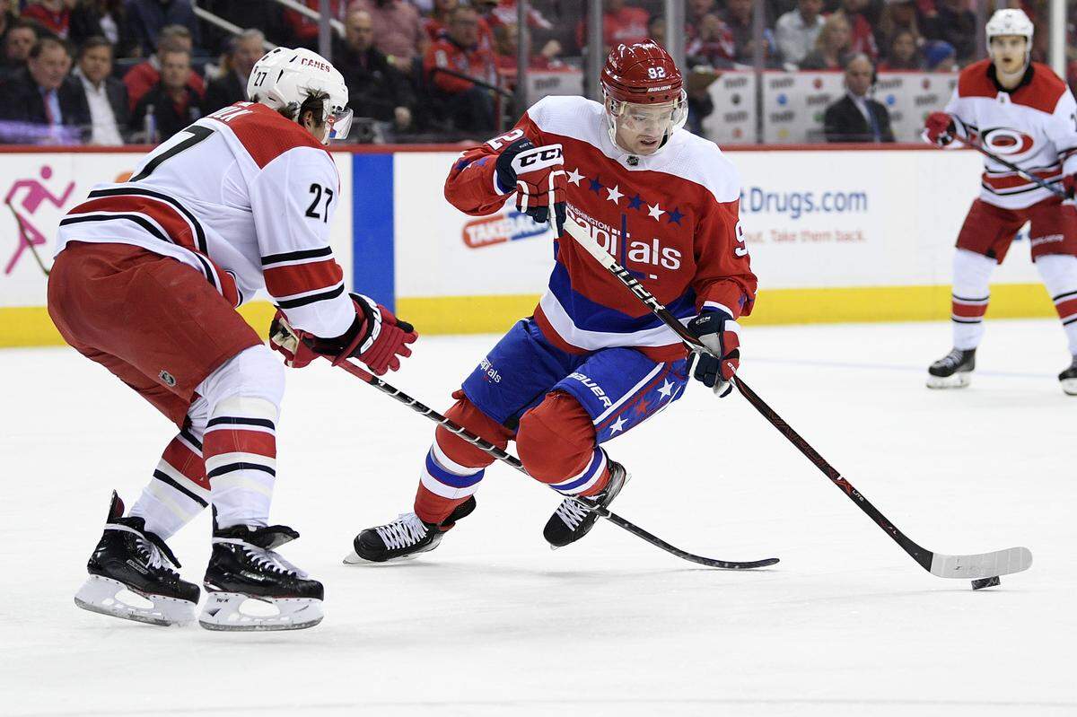 Washington Capitals center Evgeny Kuznetsov (92), of Russia, skates with the puck against Carolina Hurricanes defenseman Justin Faulk (27) during the second period of an NHL hockey game, Tuesday, March 26, 2019, in Washington. The Capitals won 4-1. (AP Photo/Nick Wass)