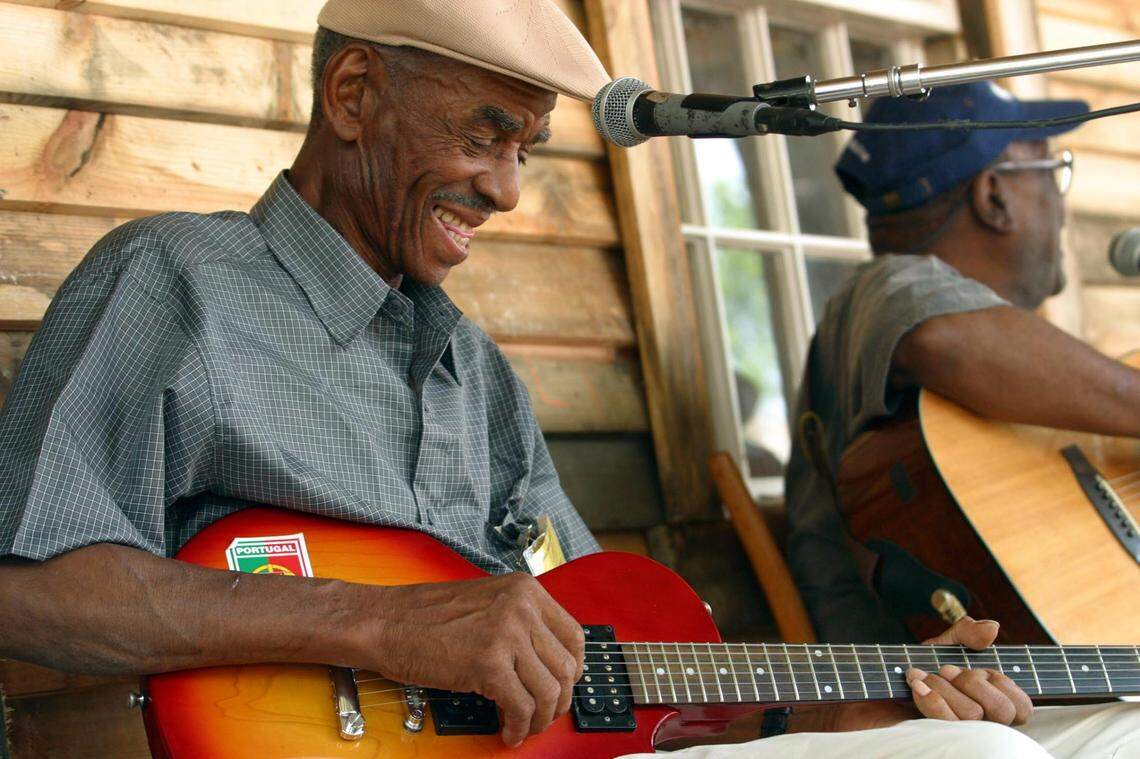 John Dee Holeman, of Durham, N.C., left, cracks a smile while playing with fellow blues man Nathaniel H. Reese, of West Virginia, during the Smithsonian Folklife Festival, which showcased the music and culture of Appalachia, as well as Scotland and Mali, on the Mall of Washington, D.C., Wednesday, June 25, 2003.