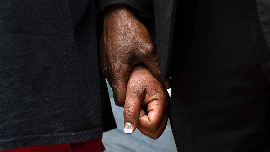 Henrietta Mason, mother of Tyrone Mason who was killed in a car crash in October 2024, holds the hand of attorney Ben Crump during a rally outside the Wake County Courthouse in Raleigh, N.C. on Thursday, May 29, 2025.