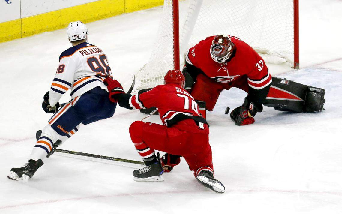 The Oilers' Jesse Puljujarvi (98) puts the puck Canes' Scott Darling (33) and Jaccob Slavin (74) for a goal in a game on March 20th.