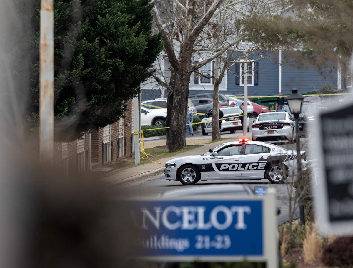 Law enforcement vehicles block a section of a parking lot at Duke Manor apartments off of LaSalle Street following a shooting on Thursday, Jan. 12, 2023, in Durham, N.C.