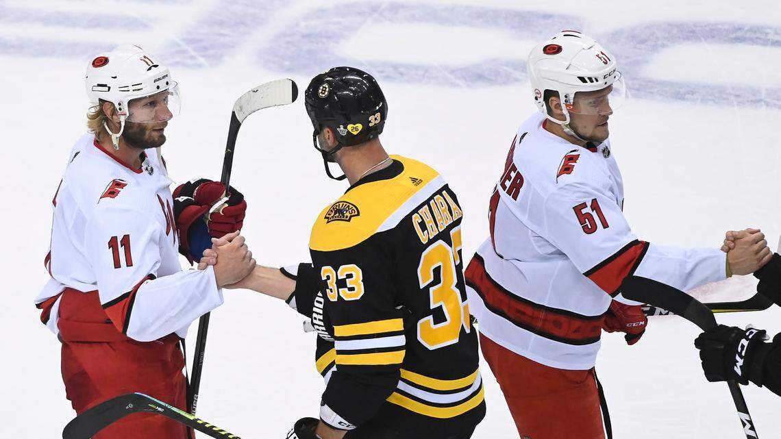 Boston Bruins captain Zdeno Chara, center, shakes hands with Carolina Hurricanes captain Jordan Staal, left, after the Bruins eliminated the Hurricanes in an NHL Eastern Conference Stanley Cup playoff hockey game in Toronto, Ontario, on Wednesday, Aug. 19, 2020. (Nathan Denette/The Canadian Press via AP)