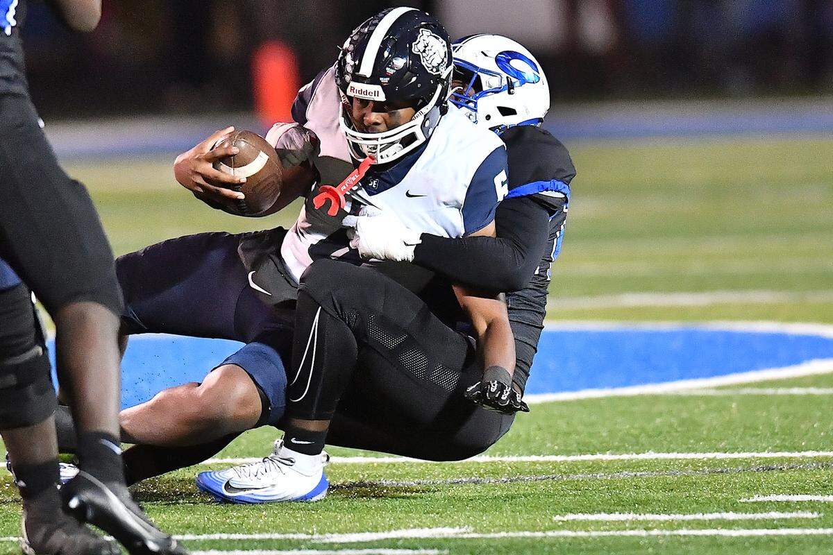 Clayton defensive lineman Kaden Blackwell (27) sacks Southeast Raleigh quarterback Tydreke Powell Jr. (6) during the second half. The Clayton Comets and the Southeast Raleigh Bulldogs met in the fourth round of the NCHSAA 7A Playoffs in Clayton, N.C. on November 28, 2025.