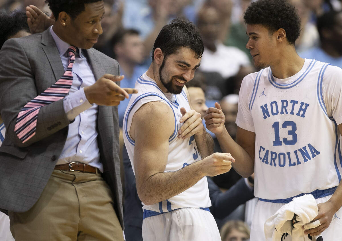 North Carolina’s Luke Maye (32) celebrates during closing minutes with teammates Sterling Manley and Cameron Johnson (13) after scoring 31 points in the Tar Heels’ 113-96 victory over N.C. State on Tuesday, February 5, 2019 at the Smith Center in Chapel Hill, N.C.