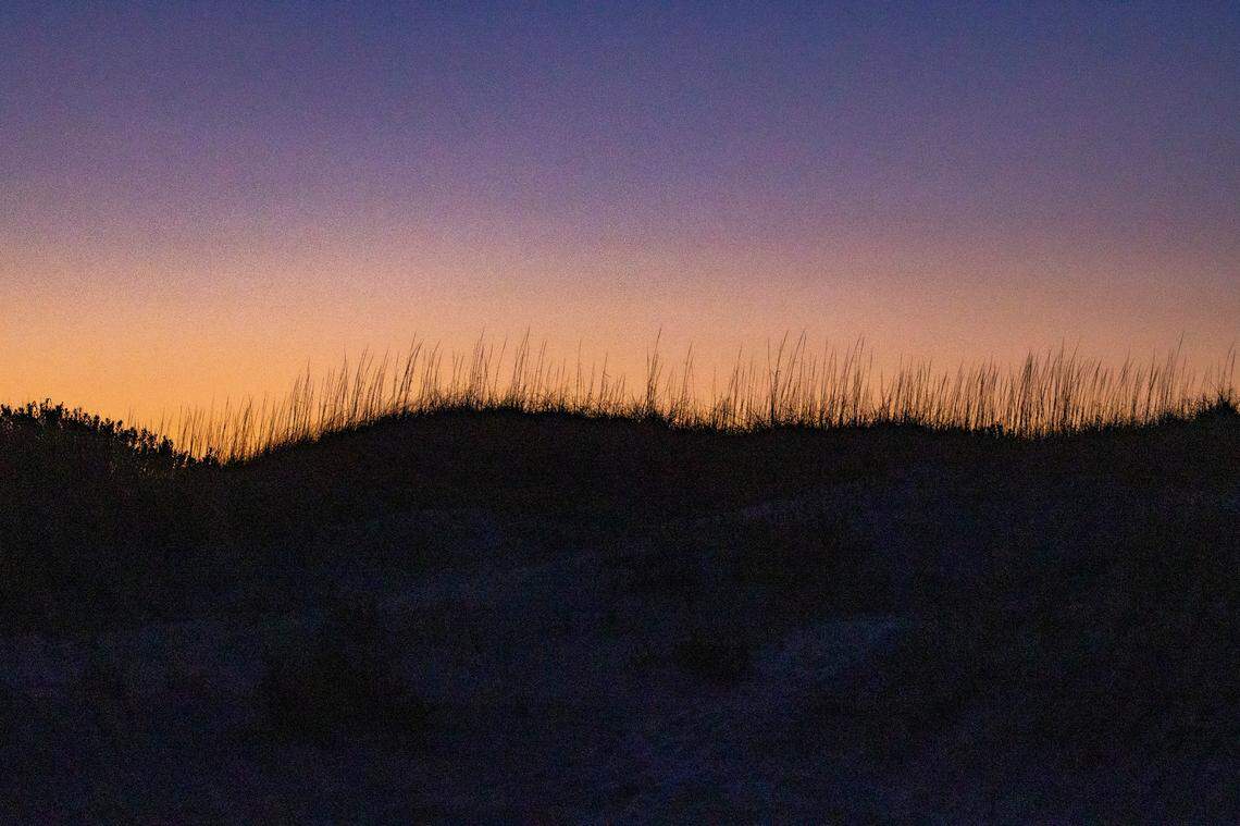 The sun sets behind a sand dune in Ocracoke Tuesday, May 17, 2022.