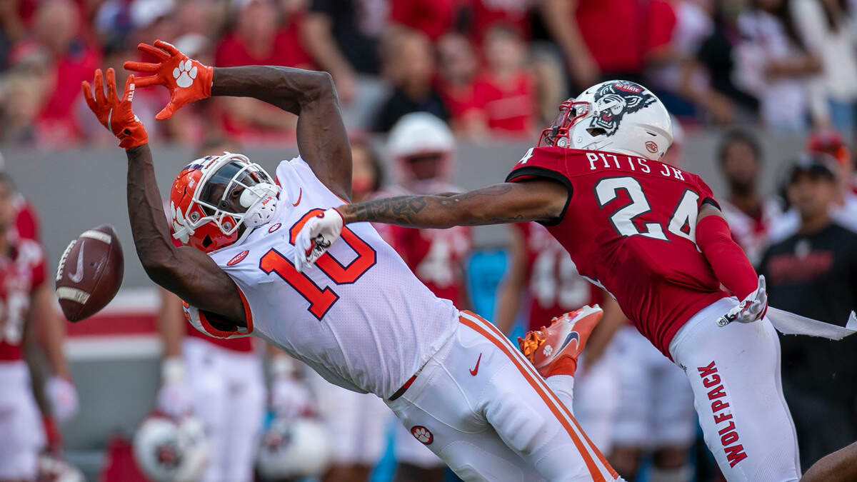N.C. State’s Derrek Pitts Jr. (24) defends Clemson’s Joseph Ngata (10) in the second quarter on Saturday September 25, 2021 at Carter-Finley Stadium in Raleigh, N.C. Pitts was penalized for pass interference on the play.