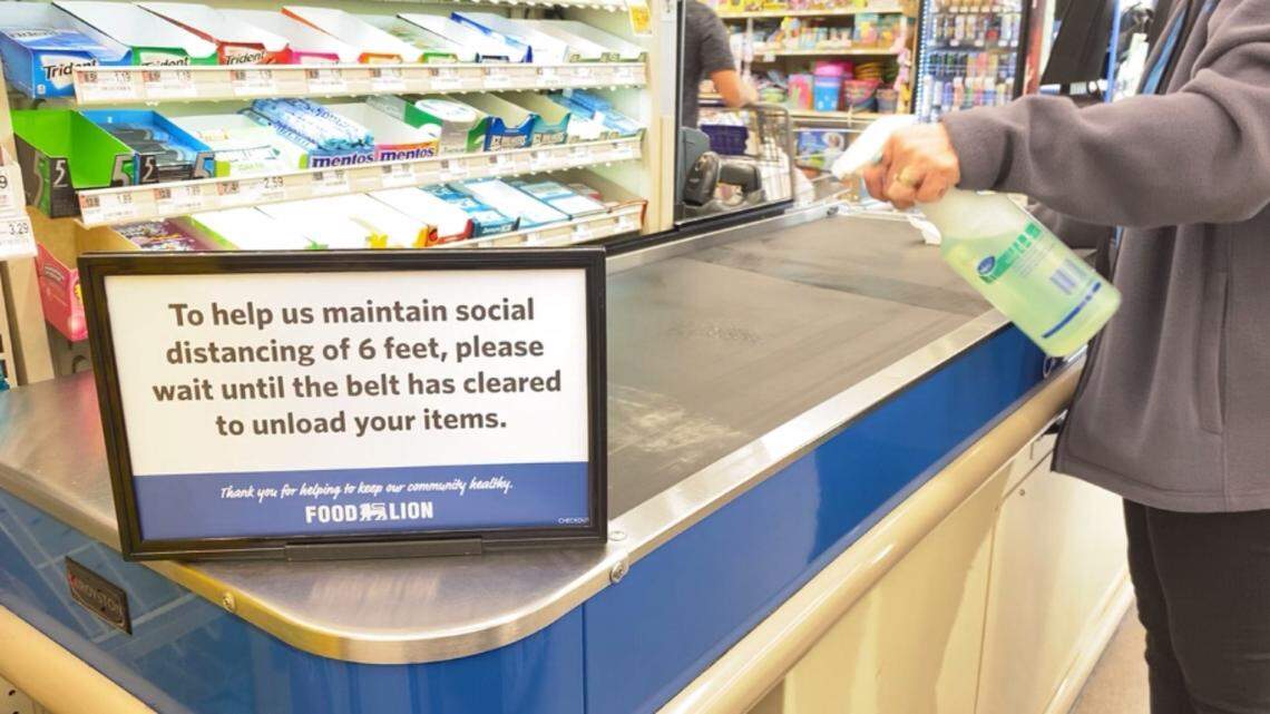 Signs placed at cash registers in Food Lion stores remind shoppers about the recommended 6-foot social distancing practice in an effort to stop the spread of COVID-19 coronavirus.