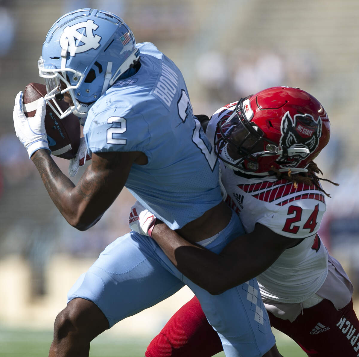 North Carolina’s Dyami Brown (2) pulls in a 21-yard pass from quarterback Sam Howell ahead of N.C. State’s Malik Dunlap (24) to set up a touchdown in the third quarter at Kenan Stadium on Saturday, October 24, 2020 in Chapel Hill, N.C.