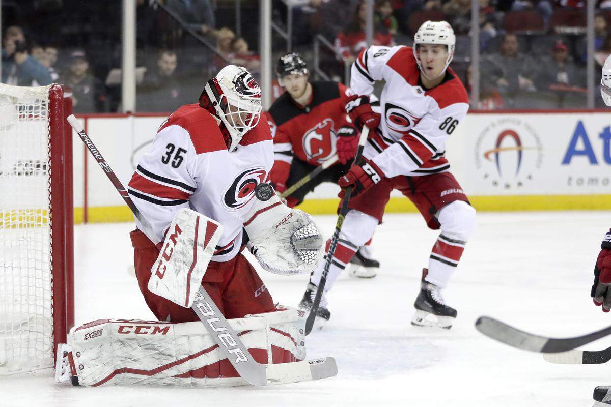 Carolina Hurricanes goaltender Curtis McElhinney (35) blocks a shot from the New Jersey Devils during the second period of an NHL hockey game, Saturday, Dec. 29, 2018, in Newark, N.J. (AP Photo/Julio Cortez)