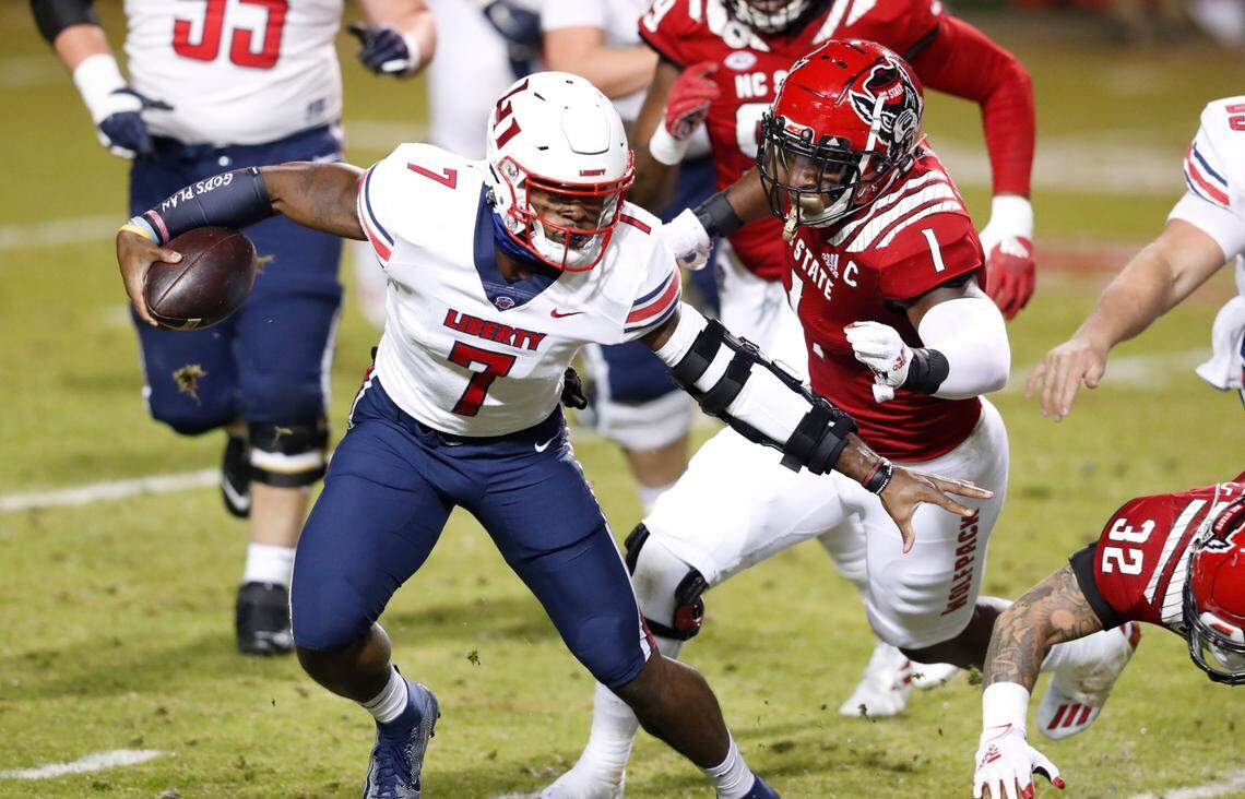 Liberty quarterback Malik Willis (7) runs upfield while being chased by N.C. State linebacker Isaiah Moore (1) during the first half of N.C. State’s game against Liberty at Carter-Finley Stadium in Raleigh, N.C., Saturday, Nov. 21, 2020.