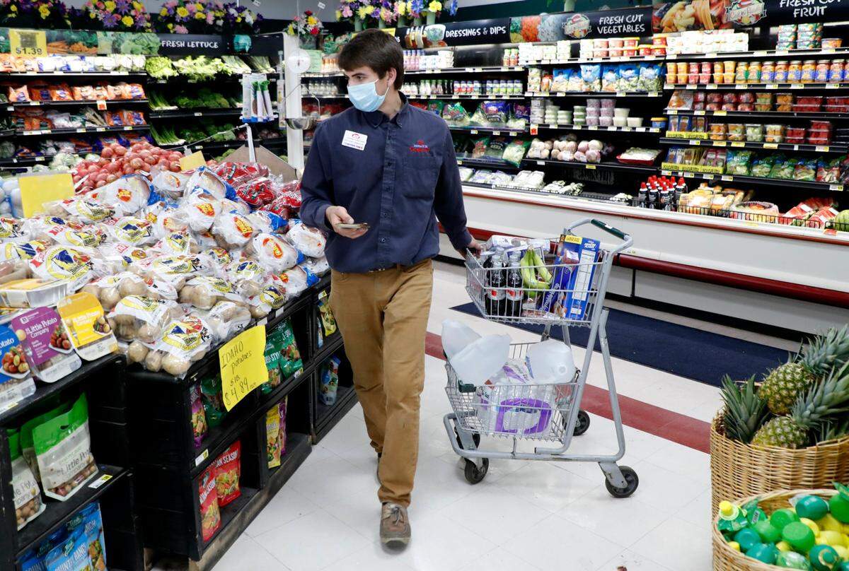 Johnny Grizzard, grocery manager at the Carlie C’s IGA in Angier, N.C., fulfills an online order while working Tuesday, April 14, 2020.