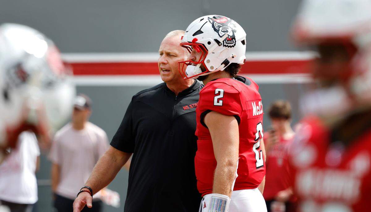 N.C. State head coach Dave Doeren talks with quarterback Grayson McCall (2) during warmups before N.C. State’s game against LA Tech at Carter-Finley Stadium in Raleigh, N.C., Saturday, Sept. 14, 2024.