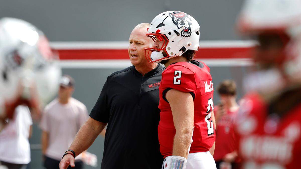 N.C. State head coach Dave Doeren talks with quarterback Grayson McCall (2) during warmups before N.C. State’s game against LA Tech at Carter-Finley Stadium in Raleigh, N.C., Saturday, Sept. 14, 2024.