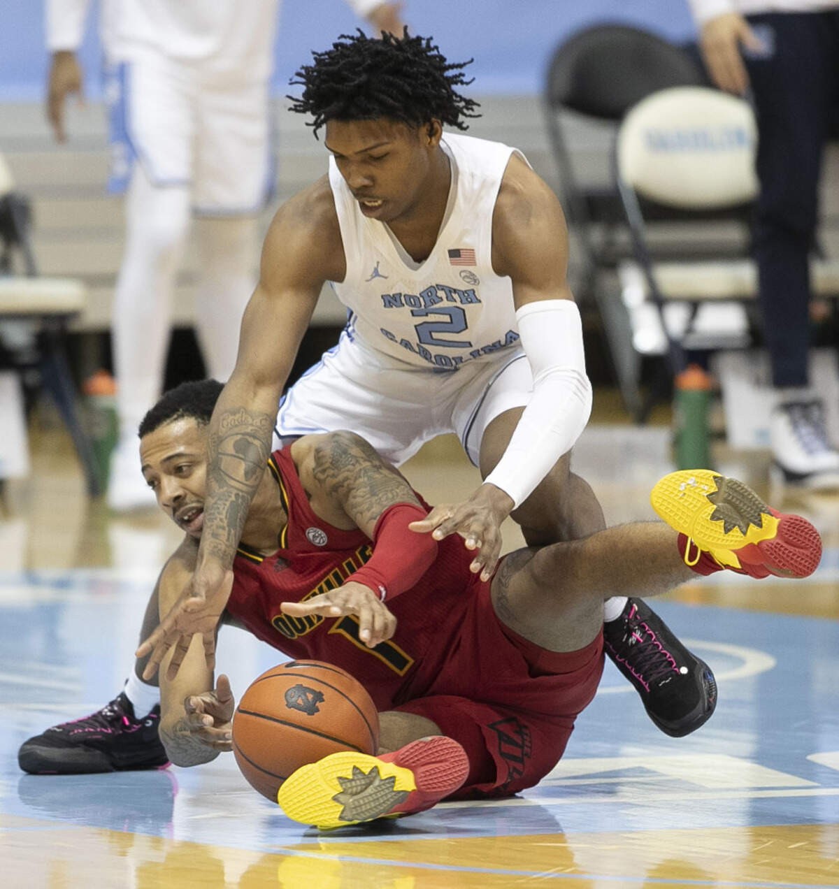 North Carolina’s Caleb Love (2) battles for a loose ball with Louisville’s Carlik Jones (1) during the first half on Saturday, February 20, 2021 at the Smith Center in Chapel Hill, N.C.