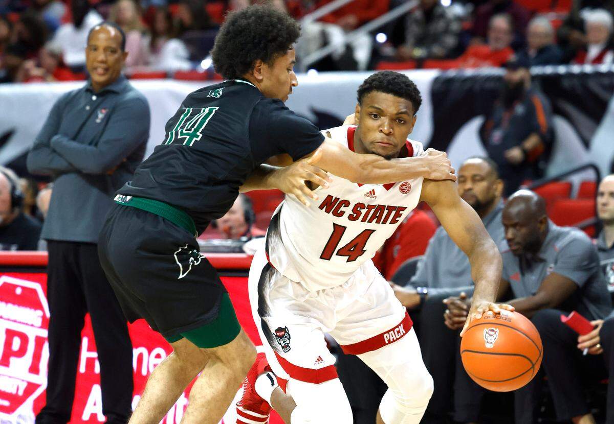 N.C. State’s Casey Morsell (14) drives around Mount Olive’s Kristopher Clark (14) during the second half of N.C. State’s 89-76 exhibition victory over Mount Olive at PNC Arena in Raleigh, N.C., Wednesday, Nov. 1, 2023.