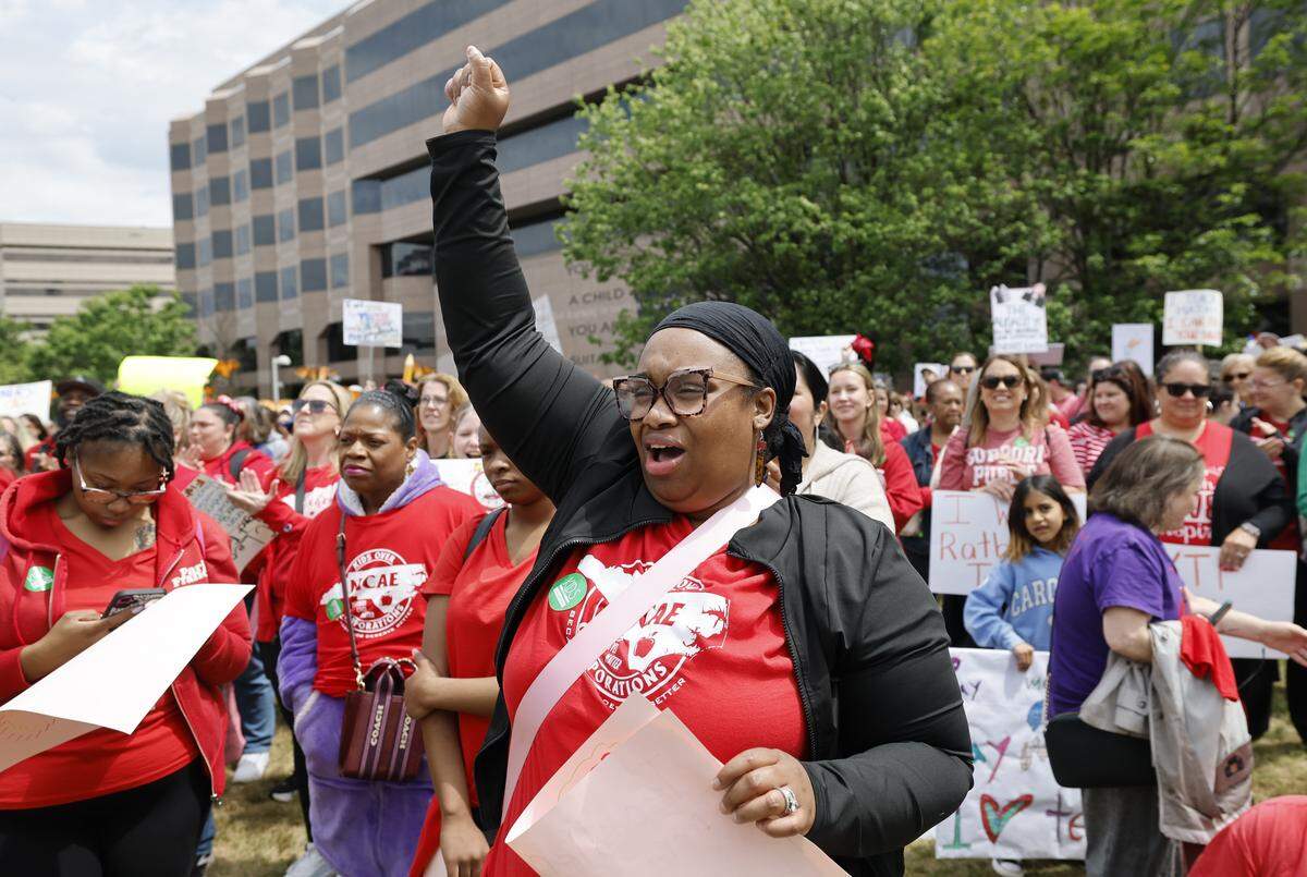 Sharie Taylor-Covington, a teacher at Zebulon Elementary School, cheers on the speakers during a rally to protest for more school funding at Halifax Mall in downtown Raleigh, N.C., Friday, May 1, 2026.  The North Carolina Association of Educators has mobilized teachers from across the state to march on the Legislative Building to demand higher pay, more school funding and higher taxes on corporations. 
