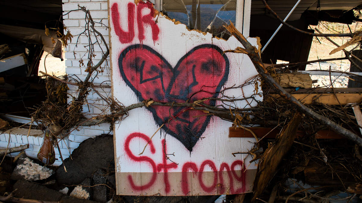 A sign of encouragement rests amid the debris of a gas station destroyed by Hurricane Helene in Swannanoa, N.C., on Oct. 26, 2024.