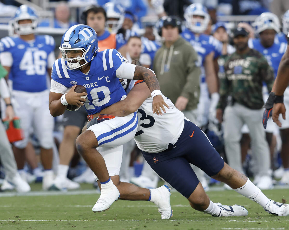 Duke quarterback Darian Mensah is sacked by Virginia’s Jacob Holmes during the first half of the Blue Devils’ game on Saturday, Nov. 15, 2025, at Wallace Wade Stadium in Durham, N.C.