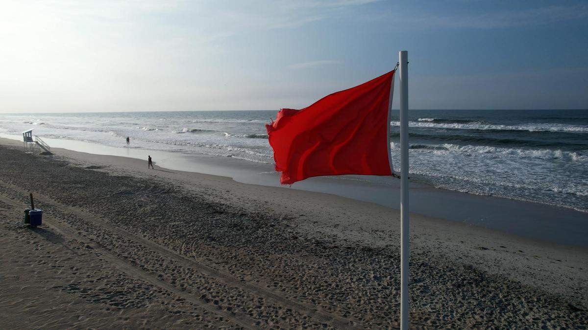 A red flag at Emerald Isle warns beachgoers to expect dangerously strong currents and rough seas if they swim in the ocean. Conditions on Friday, May 23, 2025, prompted rip-current warnings along much of the North Carolina coast.