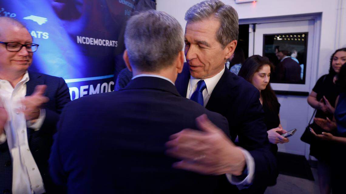 Gov. Roy Cooper celebrates with Attorney General Josh Stein after Stein spoke after winning the Democratic primary for governor.