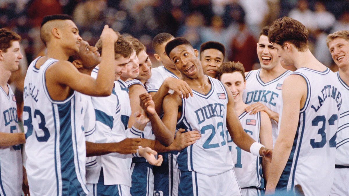 Duke’s Brian Davis (23) leads the Blue Devils in celebration at the trophy presentation after winning their first-ever NCAA Final Four championship in Indianapolis Monday, April 2, 1991. Duke defeated Kansas 72-65. At far left is Grant Hill (33), Christian Laettner (32) is at far right.