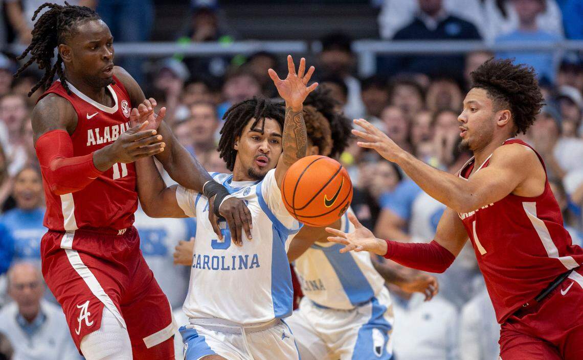 North Carolina guard Elliot Cadeau (3) tries for a steal from Alabama center Clifford Omoruyi (11) and guard Mark Sears (1) in the first half on Wednesday, December 4, 2024 at the Smith Center in Chapel Hill, N.C.