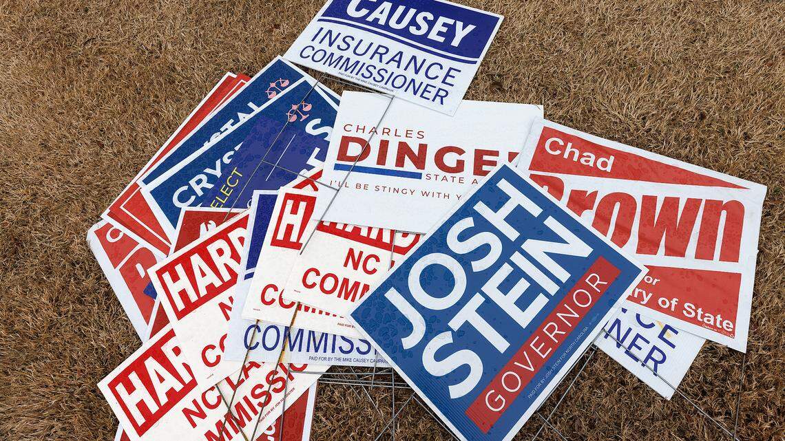 An assortment of campaign signs sits in the grass outside a voting location at the Herbert C. Young Community Center in Cary, N.C. on Tuesday, March 5, 2024.
