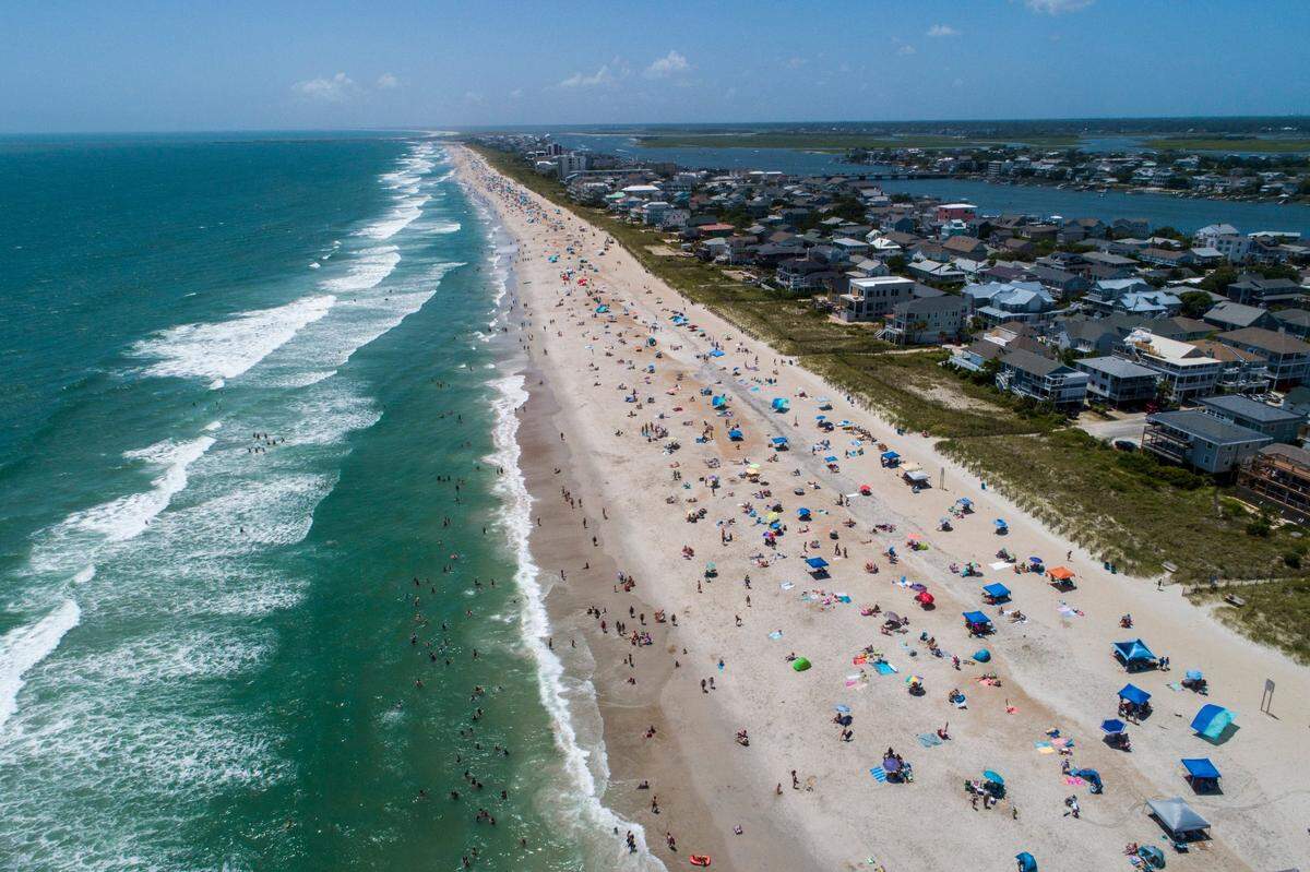 Beachgoers pack Wrightsville Beach Sunday, Aug. 2, 2020 as Tropical Storm Isaias moves along the Southeast Coast.