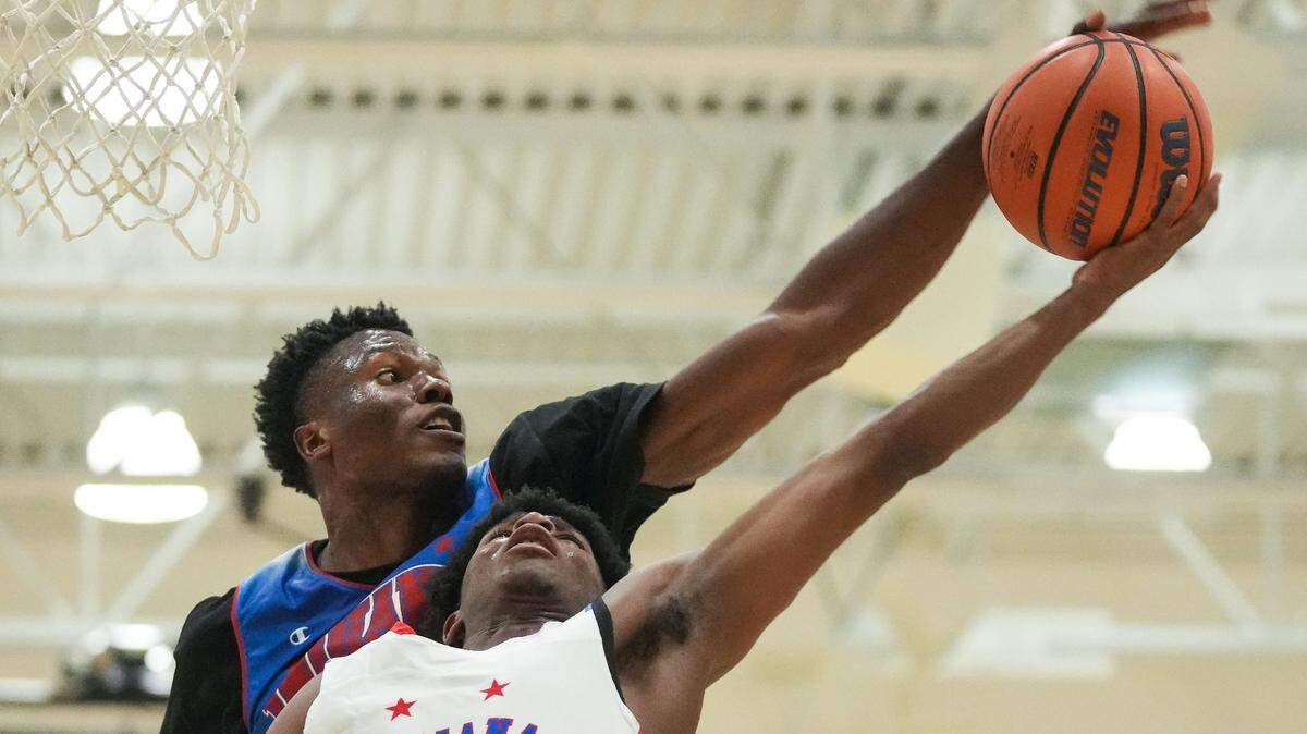 Indiana All-Star Junior Flory Bidunga (20) blocks a lay-up from Indiana All-Star Markus Burton (1) on Wednesday, June 7, 2023, during the Indiana All-Stars vs. Juniors boys game at Cathedral High School in Indianapolis.