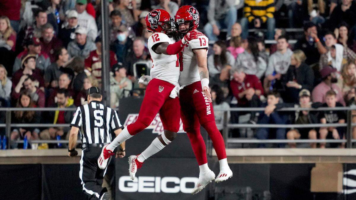 North Carolina State linebacker Devan Boykin (12) celebrates with teammate Devin Leary (13) after returning a botched punt for a touchdown during the second half of an NCAA college football game against Boston College, Saturday, Oct. 16, 2021, in Boston.