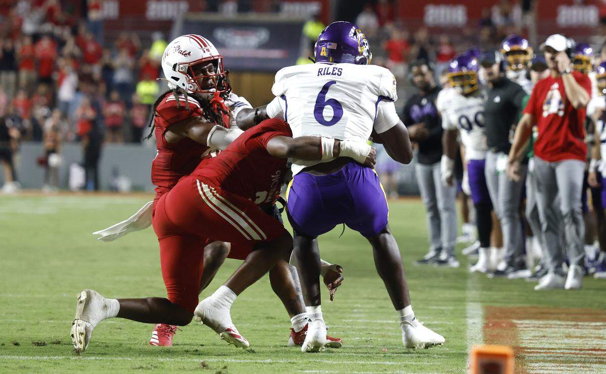 With 40 seconds left in the game, on fourth-and-1 from the Wolfpack 9, N.C. State safety Ronnie Royal III (2) stops East Carolina tight end Desirrio Riles (6) for a loss to give the Wolfpack the eventual 24-17 victory over ECU at Carter-Finley Stadium in Raleigh, N.C., Thursday, Aug. 28, 2025.