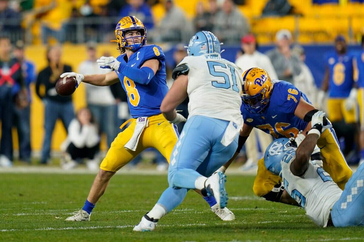 Pittsburgh quarterback Kenny Pickett (8) prepares to throw a pass that went for a touchdown, as North Carolina defensive lineman Raymond Vohasek (51) rushes during the first half of an NCAA college football game, Thursday, Nov. 11, 2021, in Pittsburgh. (AP Photo/Keith Srakocic)
