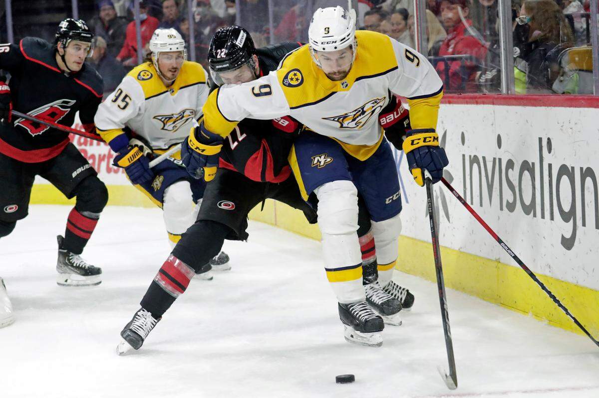 Nashville Predators left wing Filip Forsberg (9) and Carolina Hurricanes defenseman Brett Pesce (22) vie for the puck as Predators center Matt Duchene (95) and Hurricanes center Vincent Trocheck (16) look on during the first period of an NHL hockey game Friday, Feb. 18, 2022, in Raleigh, N.C. (AP Photo/Chris Seward)