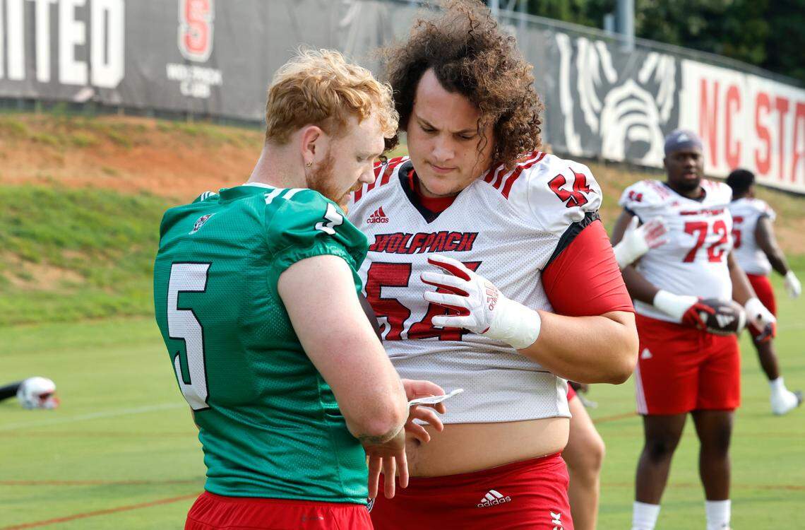 N.C. State quarterback Brennan Armstrong (5) talks with offensive lineman Dylan McMahon (54) during the Wolfpack’s first fall practice in Raleigh, N.C., Wednesday, August 2, 2023.