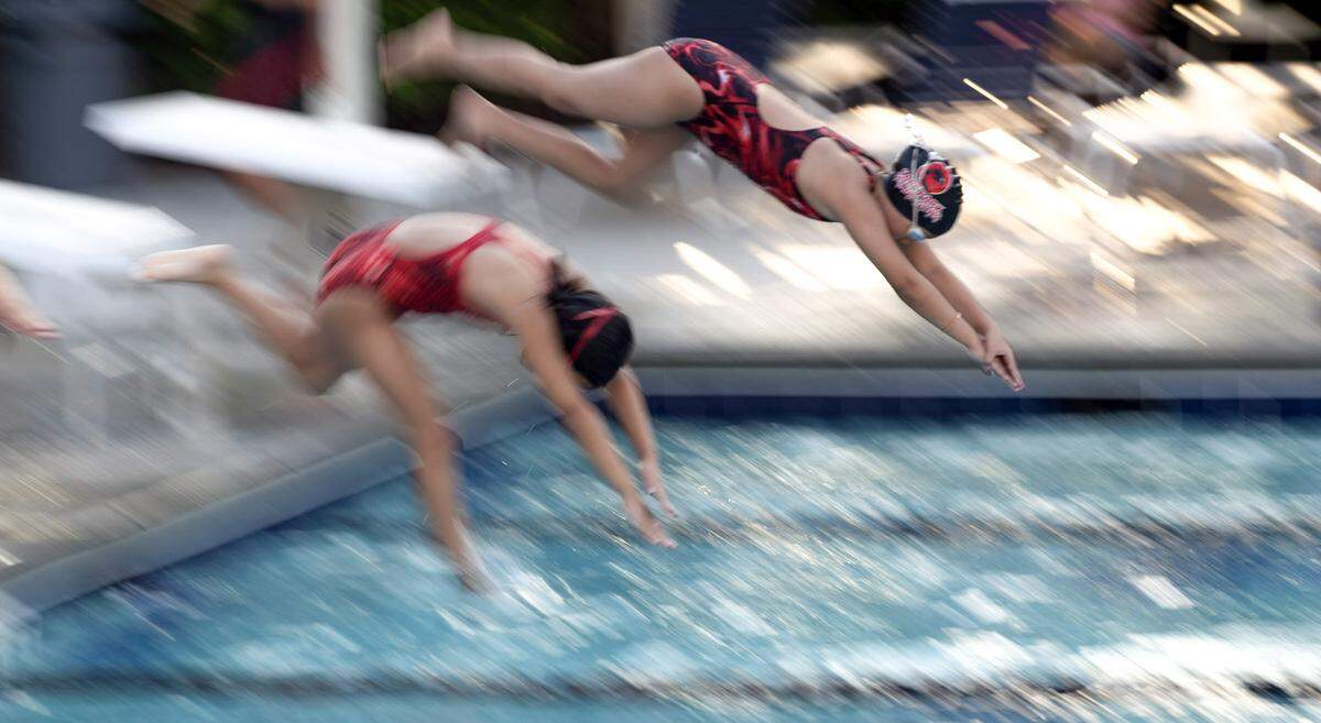 Mia Liu and Dayoon Kim practice their dives during practice at the Cary Park Swim Club on June 24, 2024.