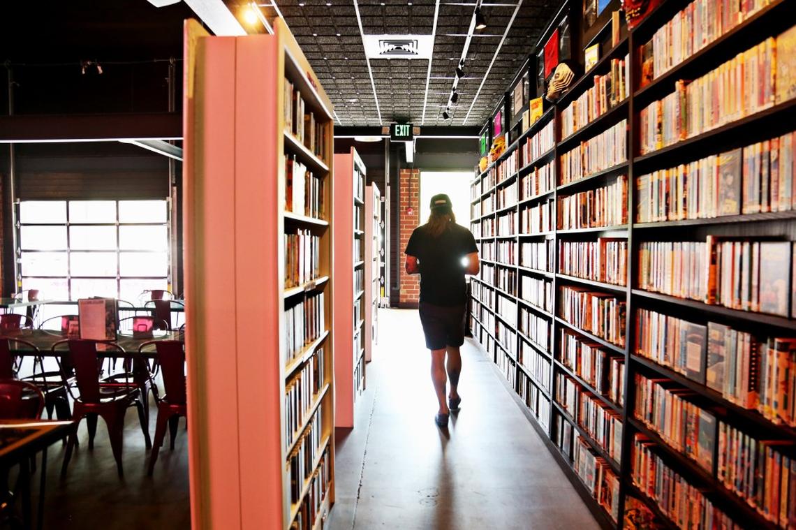 Josh Schafer, who works as the co-manager and "VHS Culture Captain" at Alamo Drafthouse Cinema in Raleigh, looks over the shelves of VHS tapes that can be rented for free on Friday afternoon, June 15, 2018. The Alamo Drafthouse aims to bring back old-fashioned videotapes with Video Vortex located at the front of the cinema.