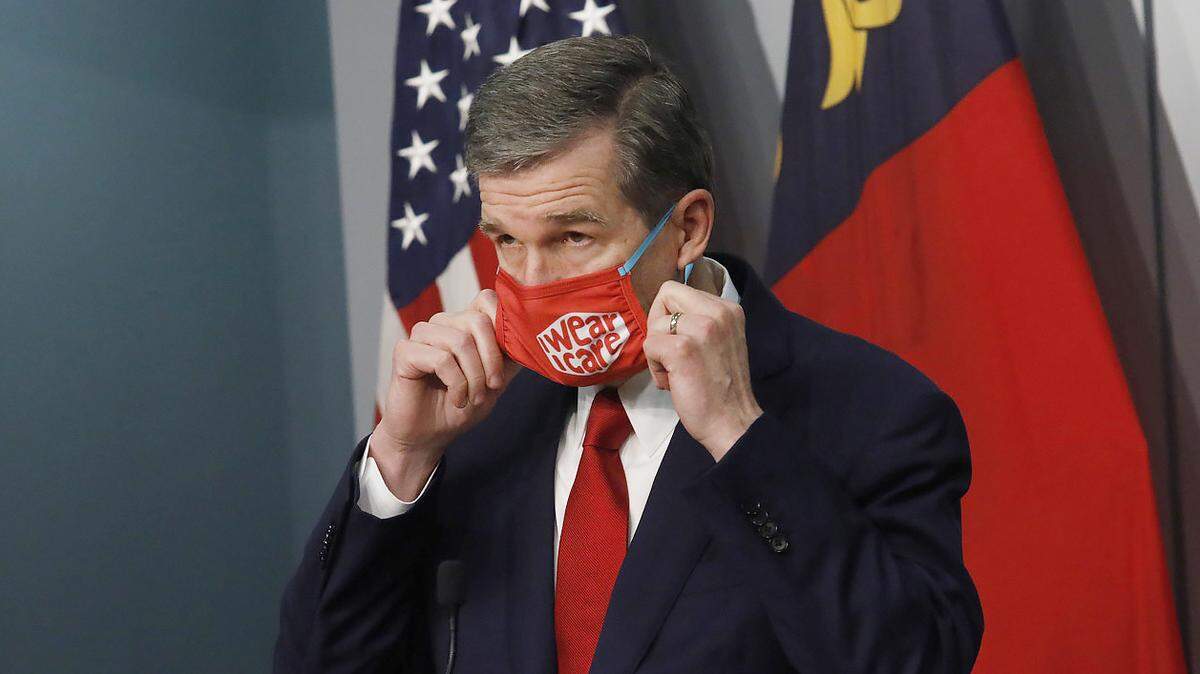 Gov. Roy Cooper removes his mask before speaking during a briefing on North Carolina’s coronavirus pandemic response Tuesday, Dec. 1, 2020 at the NC Emergency Operations Center in Raleigh.